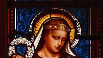 St. Thecla. Who was Thecla? The saint, rebel, and leading lady of the Acts of Thecla is depicted on this stained glass window from the Basilica of Ars in France. Photo: Vassil by CC0-1.0.