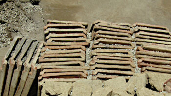 Stacks of building materials found in the atrium of the Pompeii town house, including stone blocks, tuff, orderly rows of roof tiles. Image courtesy of Italian Ministry of Culture