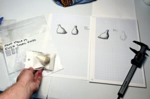 The tools of the archaeological illustrator’s trade, showing millimeter-grid paper with an object, object sketch, and digital calipers. Photo courtesy James Gold.