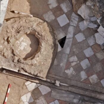 Side by side of archaeological remains of baptismal font with modern illustration. floor is checkered with red and white tiles. Courtesy Michael Eisenberg