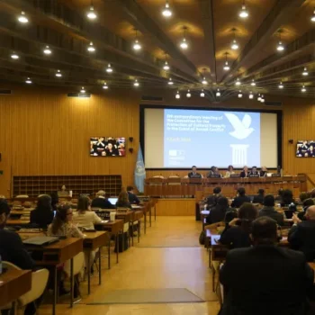 People sitting in seats in front of a projection screen in a large room. Courtesy UNESCO