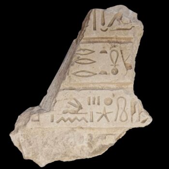 sandstone fragment with inscribed hieroglyphs on a black background. Courtesy Egyptian Ministry of Tourism and Antiquities