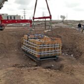 crane lifting rectangular basin from the ground. Courtesy Israel Antiquities Authority