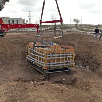 crane lifting rectangular basin from the ground. Courtesy Israel Antiquities Authority